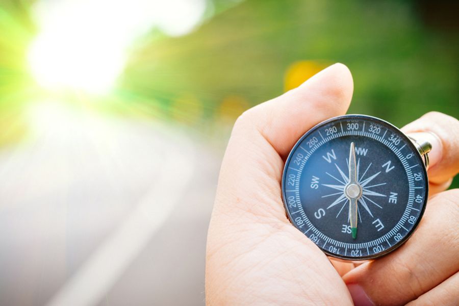 Kompass inHand, im Hintergrund Sonnenlicht